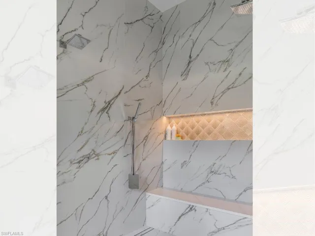Primary bathroom shower featuring  large format tile and multiple shower heads