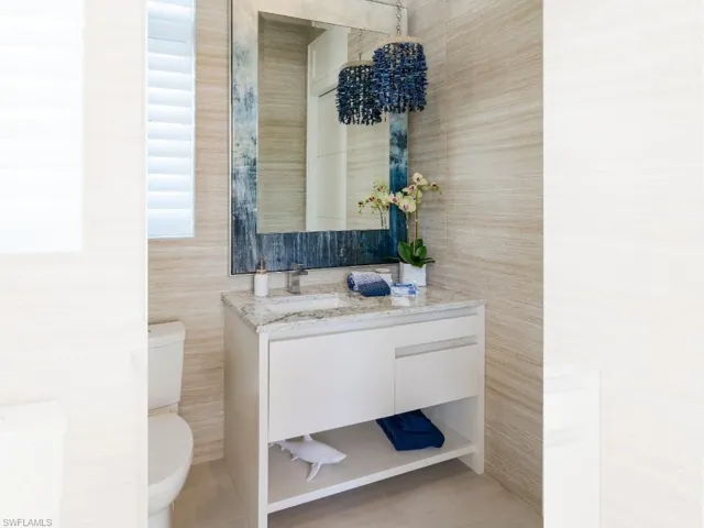Pool bath full tiled walls, custom mirror and shell chandelier