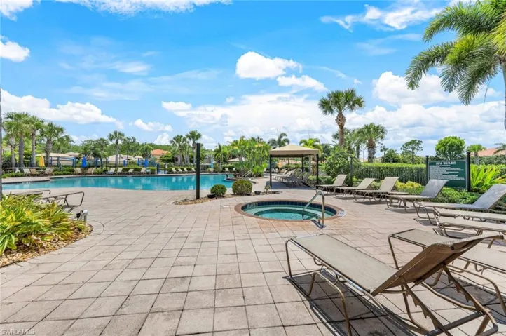 View of swimming pool featuring a patio and a hot tub