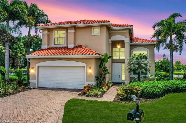 Mediterranean / spanish-style home with a garage and a yard