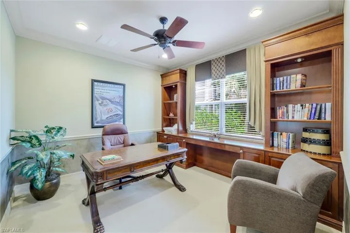 Home office featuring light carpet, ceiling fan, and crown molding