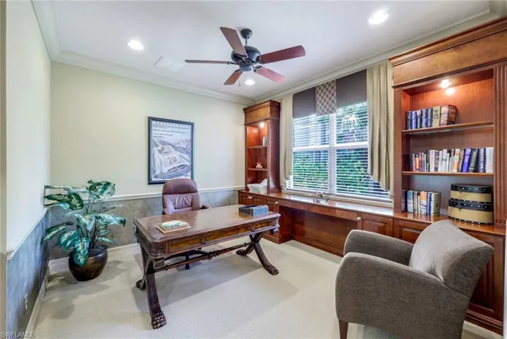 Office area with crown molding, ceiling fan, and light colored carpet