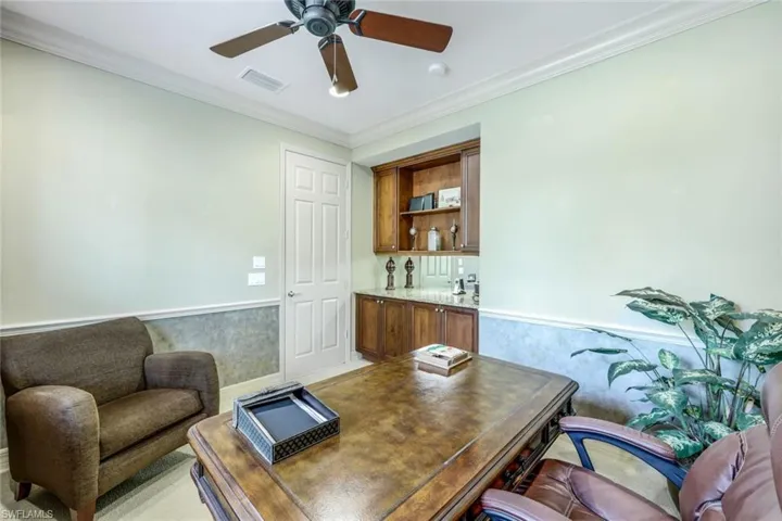 Office area featuring ceiling fan and ornamental molding