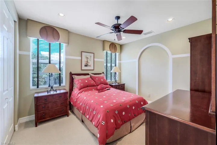 Carpeted bedroom featuring a closet and ceiling fan