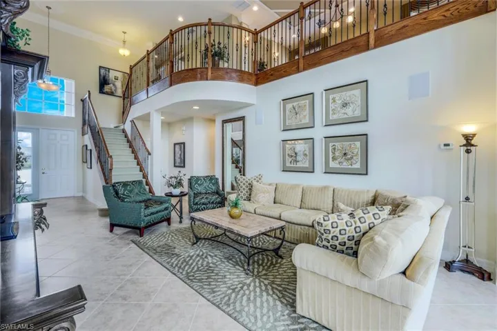 Tiled living room with a high ceiling and crown molding