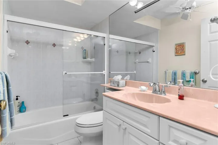 Bathroom featuring shower / bath combination with glass door, vanity, and tile patterned floors