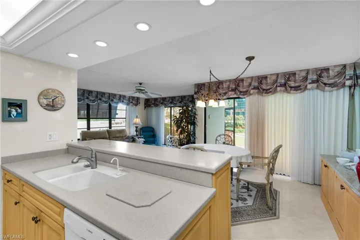 Kitchen with light brown cabinetry, open floor plan, dishwasher, a ceiling fan, and recessed lighting