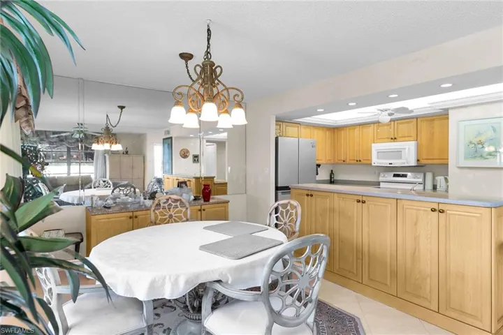 Dining space featuring recessed lighting, a chandelier, light tile patterned floors, ceiling fan, and a textured ceiling