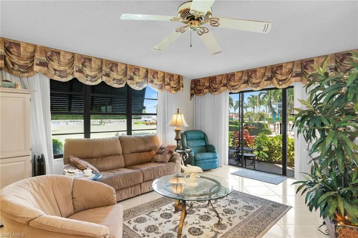 Living room featuring light tile patterned flooring, a ceiling fan, and a textured ceiling