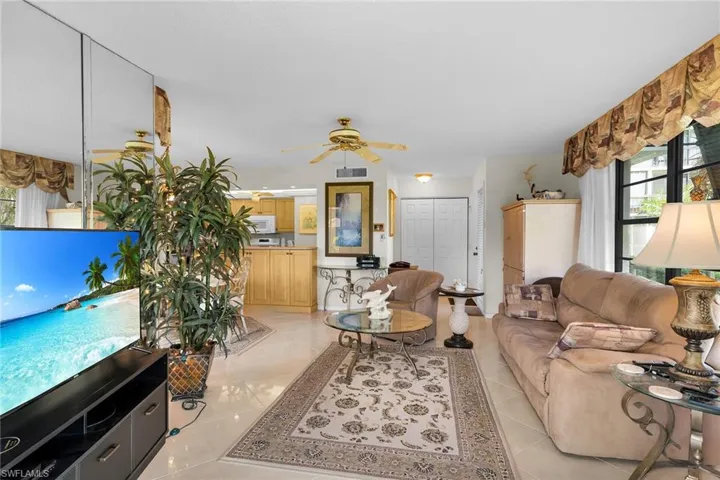 Living room with plenty of natural light, a ceiling fan, and light tile patterned floors