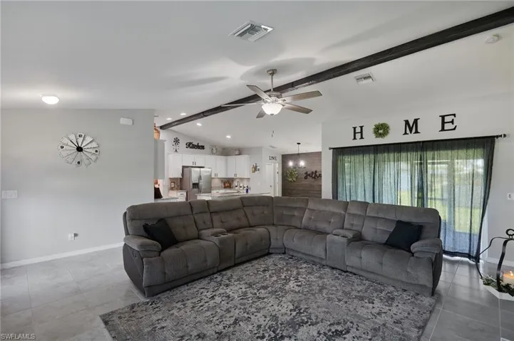 Living area with a ceiling fan and baseboards