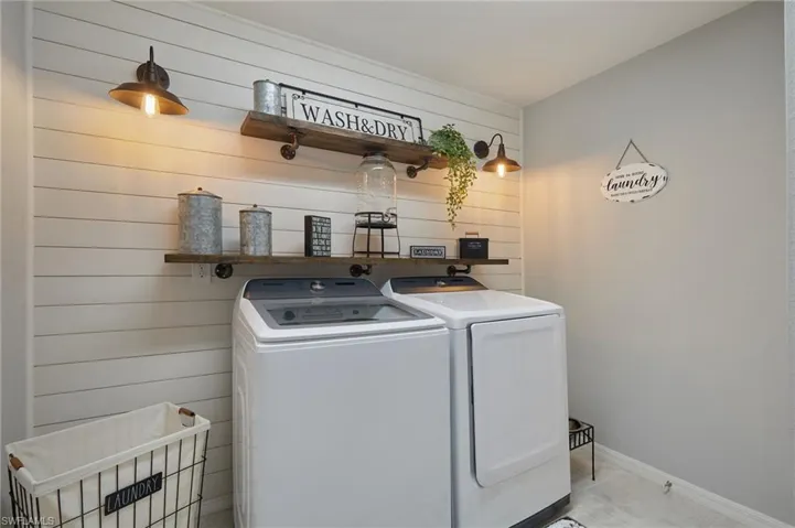 Laundry area featuring independent washer and dryer and wood walls