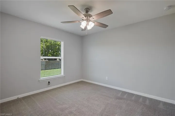 Spare room featuring light carpet and a ceiling fan