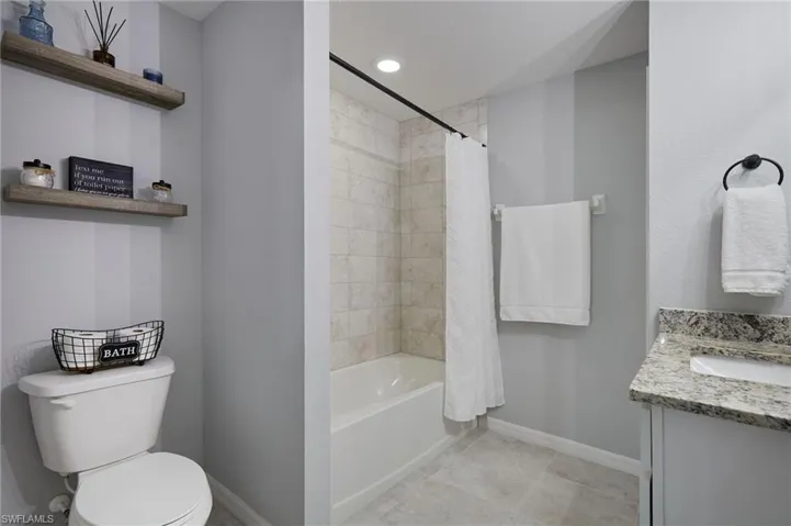 Full bathroom featuring shower / bath combo, vanity, recessed lighting, and light tile patterned floors
