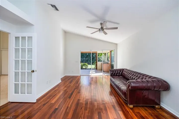 Living room featuring ceiling fan, dark hardwood / wood-style flooring, and lofted ceiling