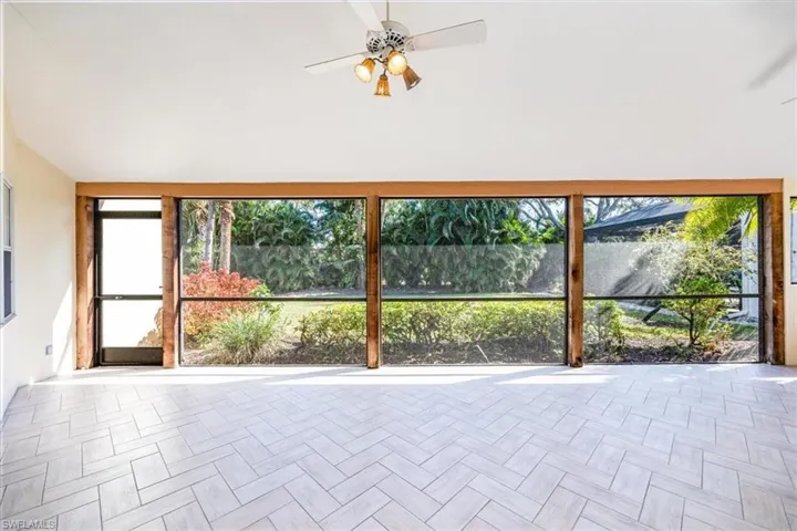 Unfurnished sunroom with ceiling fan and plenty of natural light