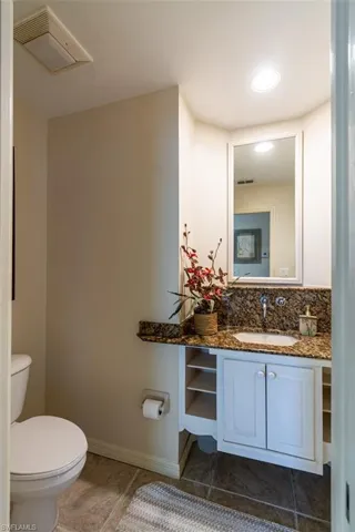 Half bathroom with vanity and light tile patterned floors