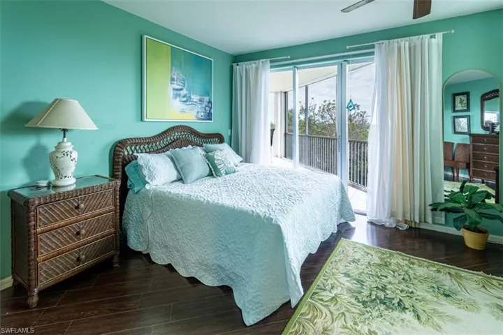 Bedroom featuring wood finish floors, access to outside, and a ceiling fan