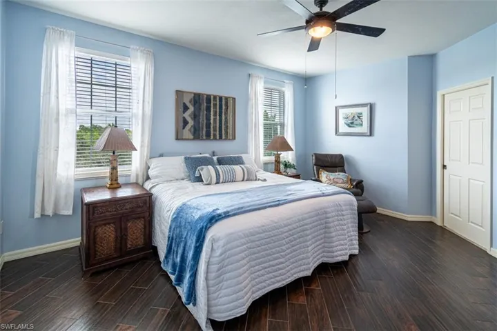 Bedroom with dark wood-style flooring and a ceiling fan