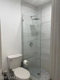 Bathroom featuring a stall shower and toilet