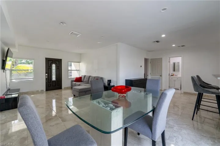 Dining room featuring recessed lighting and light marble finish floors