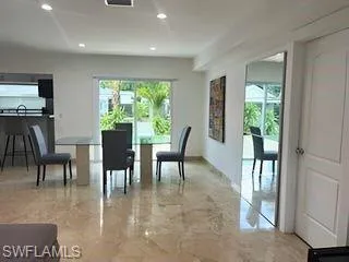 Dining area featuring recessed lighting and light marble finish floors