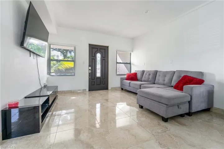 Living area with healthy amount of natural light and light marble finish flooring