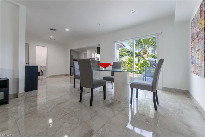 Dining space with recessed lighting and light marble finish floors