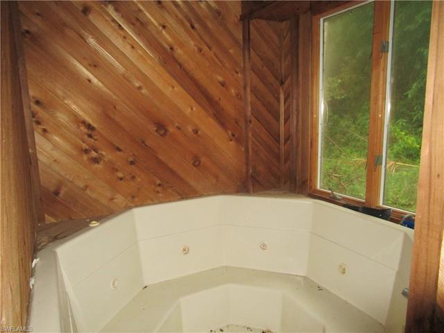 Master jetted soaker tub facing wooded area