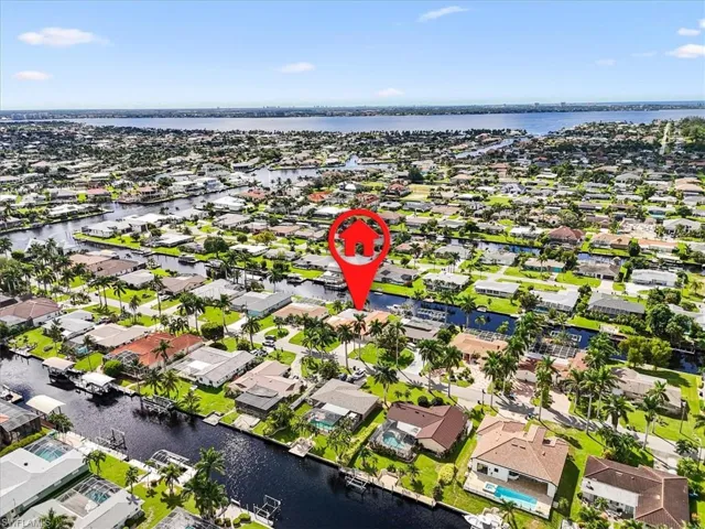 Aerial view of property and surrounding area featuring a large body of water and nearby suburban area