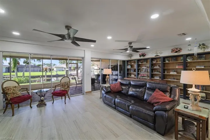Living area with recessed lighting, light wood-style floors, crown molding, and ceiling fan