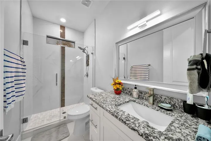 Bathroom with vanity, toilet, and walk in shower