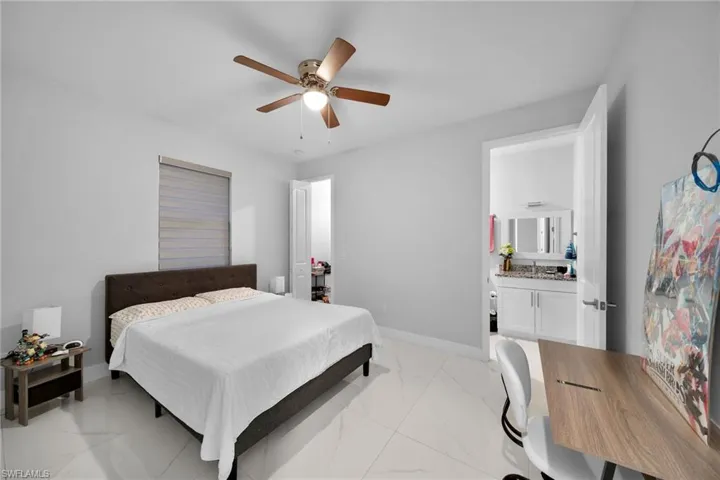 Bedroom featuring ceiling fan and connected bathroom