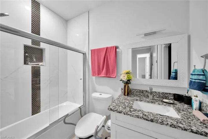 Full bathroom with vanity, toilet, and combined bath / shower with glass door