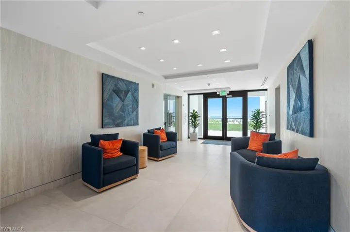 Community lobby with floor to ceiling windows, a raised ceiling, and recessed lighting