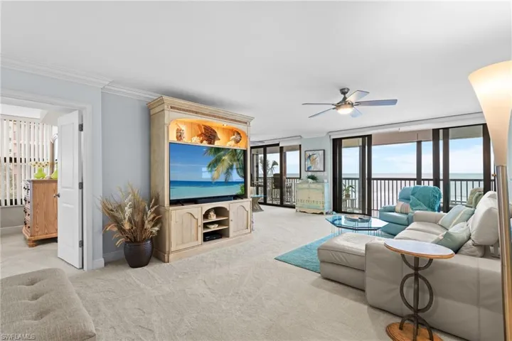Living room featuring crown molding, light carpet, and ceiling fan