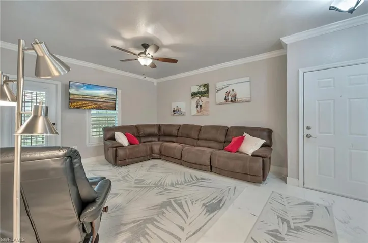 Living area with crown molding and a ceiling fan