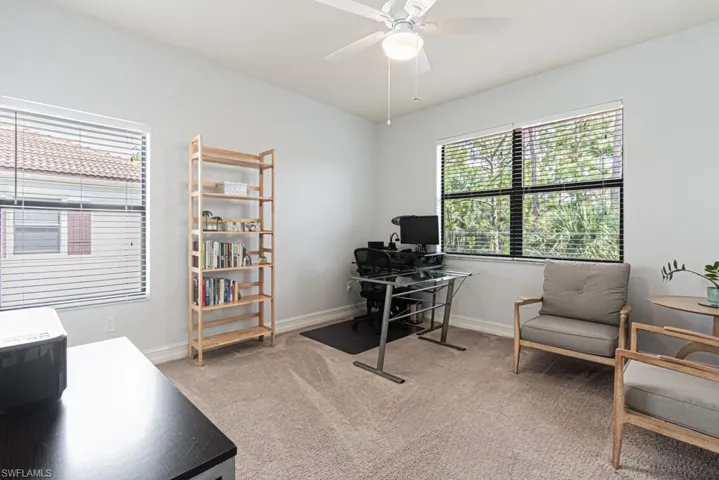 Office space with light colored carpet and a ceiling fan