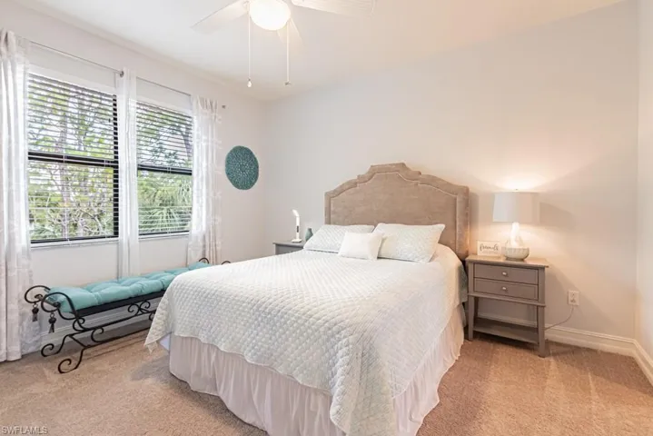 Bedroom with light colored carpet and a ceiling fan