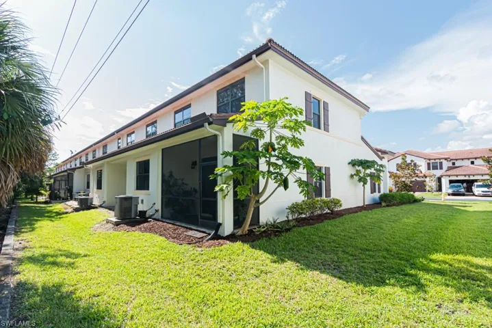Rear view of house with stucco siding and a yard