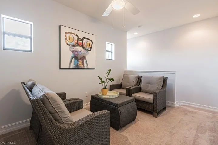Sitting room with light colored carpet, ceiling fan, and recessed lighting