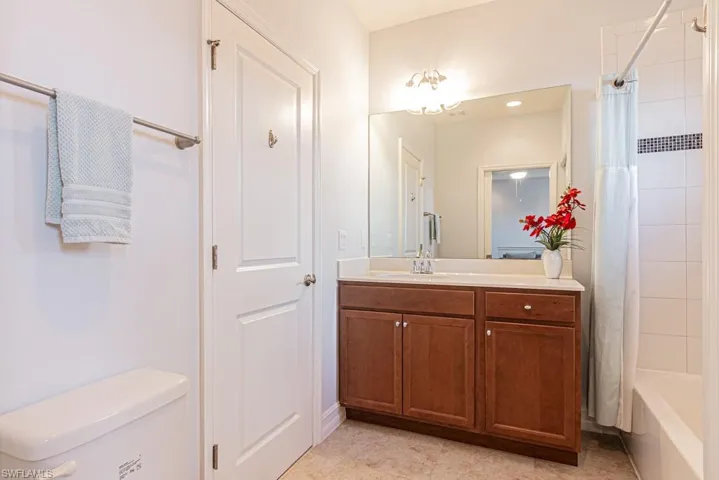 Bathroom featuring vanity and shower / bathtub combination with curtain