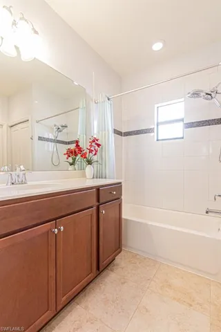Full bath featuring shower / bathtub combination with curtain, tile patterned floors, vanity, and recessed lighting