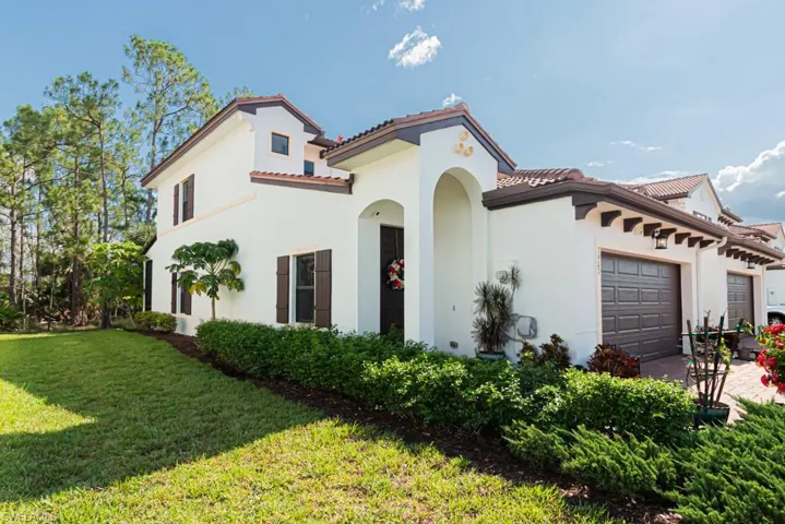 Mediterranean / spanish home featuring an attached garage, stucco siding, a tiled roof, and a front yard