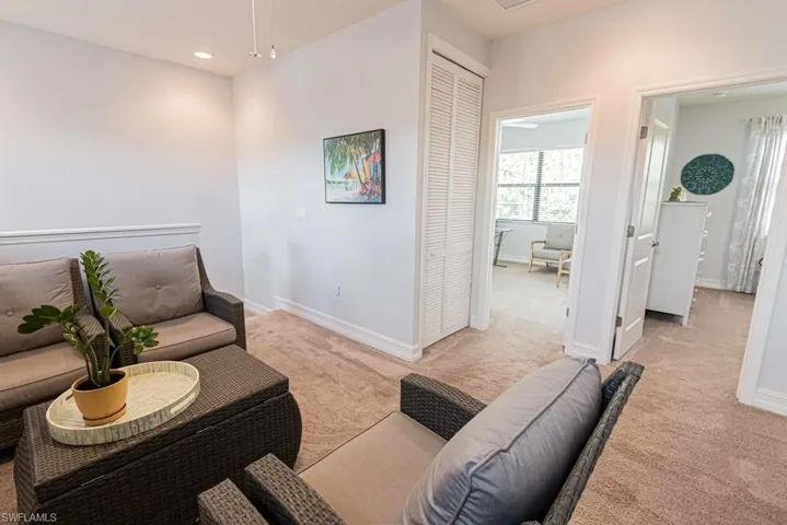 Living room with light colored carpet and recessed lighting