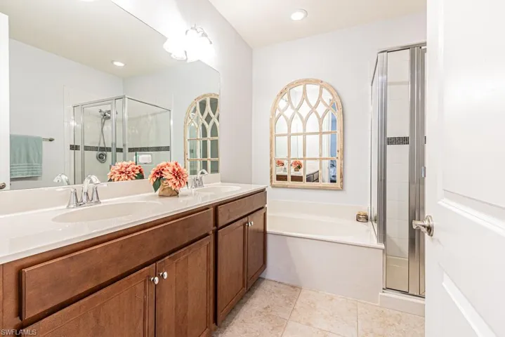 Bathroom with a stall shower, double vanity, a bath, tile patterned floors, and recessed lighting