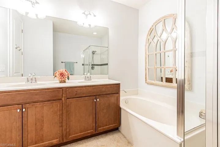 Bathroom with a stall shower, a bath, and double vanity