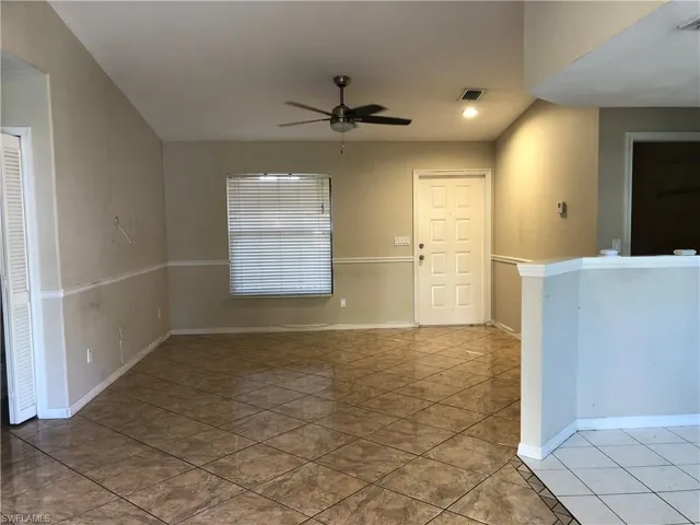 Tiled spare room with a ceiling fan and baseboards