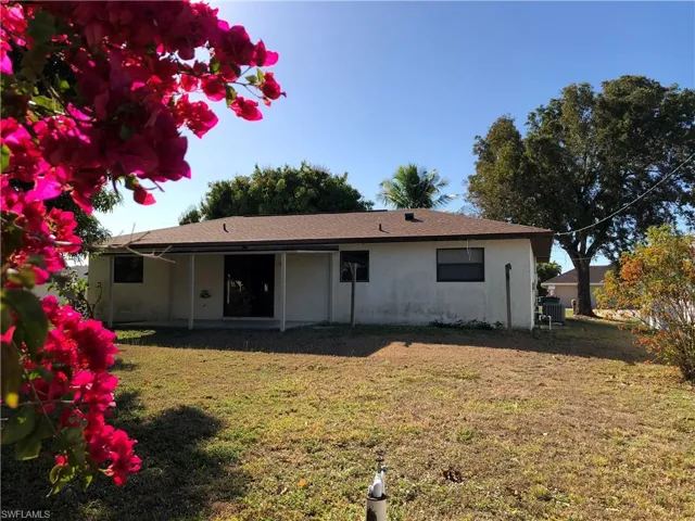 Rear view of property featuring a yard, a patio area, and stucco siding