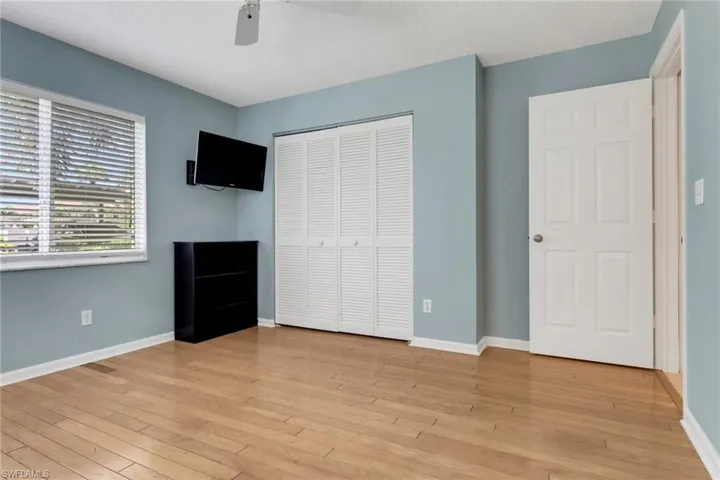 Unfurnished bedroom with a closet, light wood finished floors, ceiling fan, and a textured ceiling